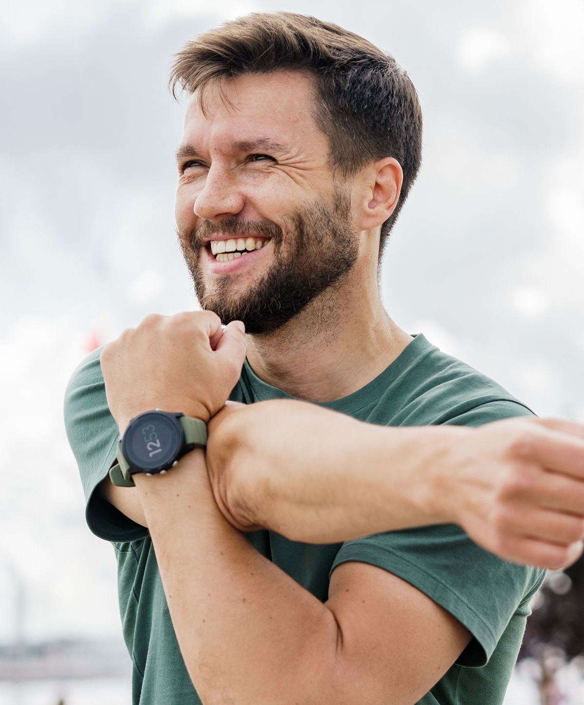 Man stretching with a smartwatch on his wrist.