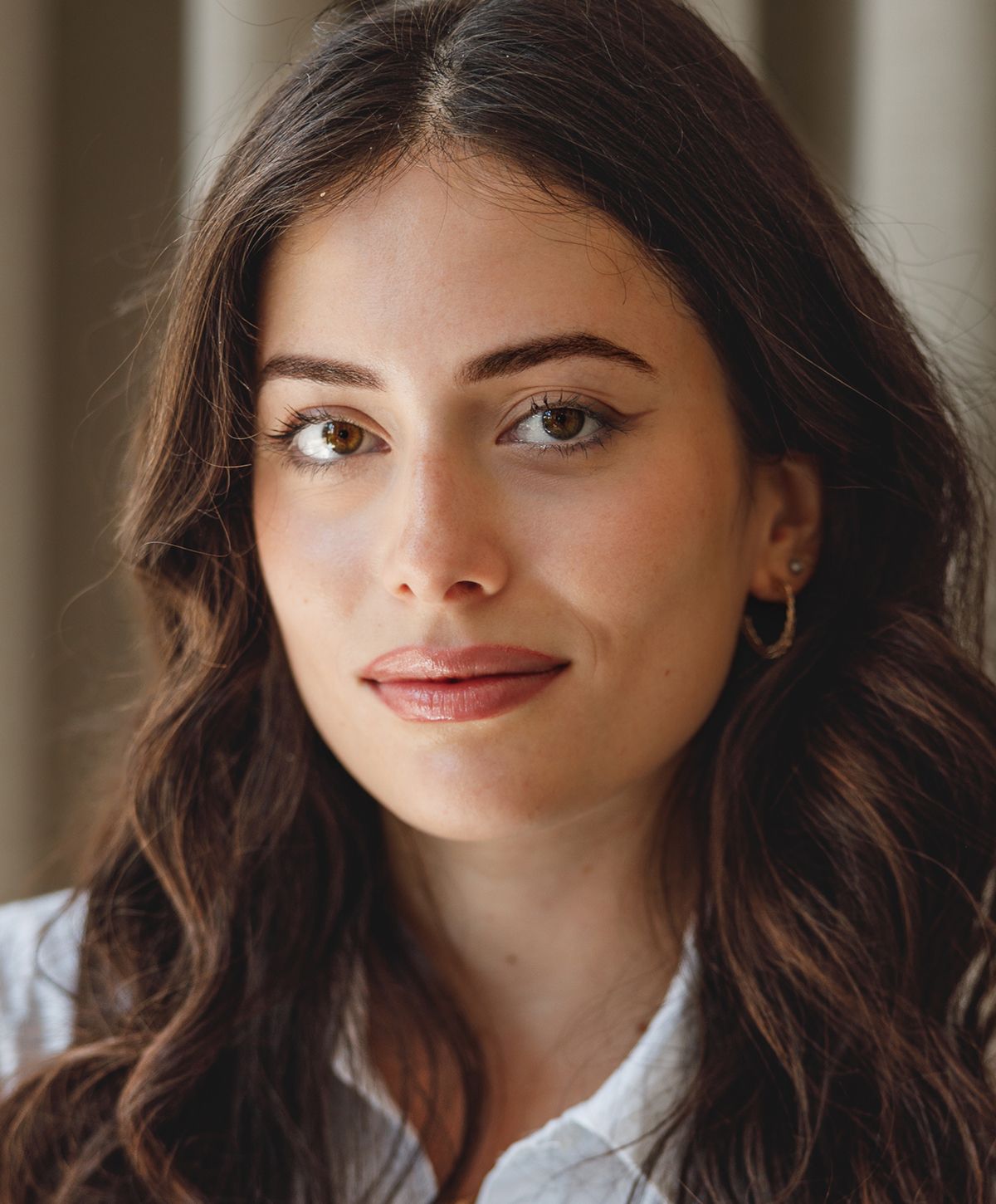 Smiling woman with wavy hair and natural makeup.