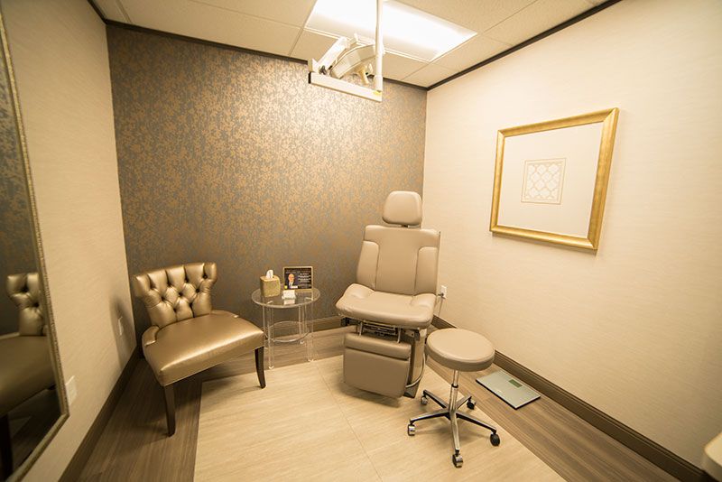 Medical consultation room with seating and equipment.