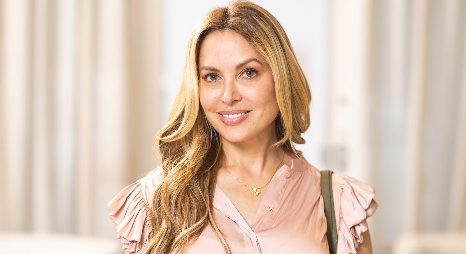 Smiling woman with long, wavy blonde hair.