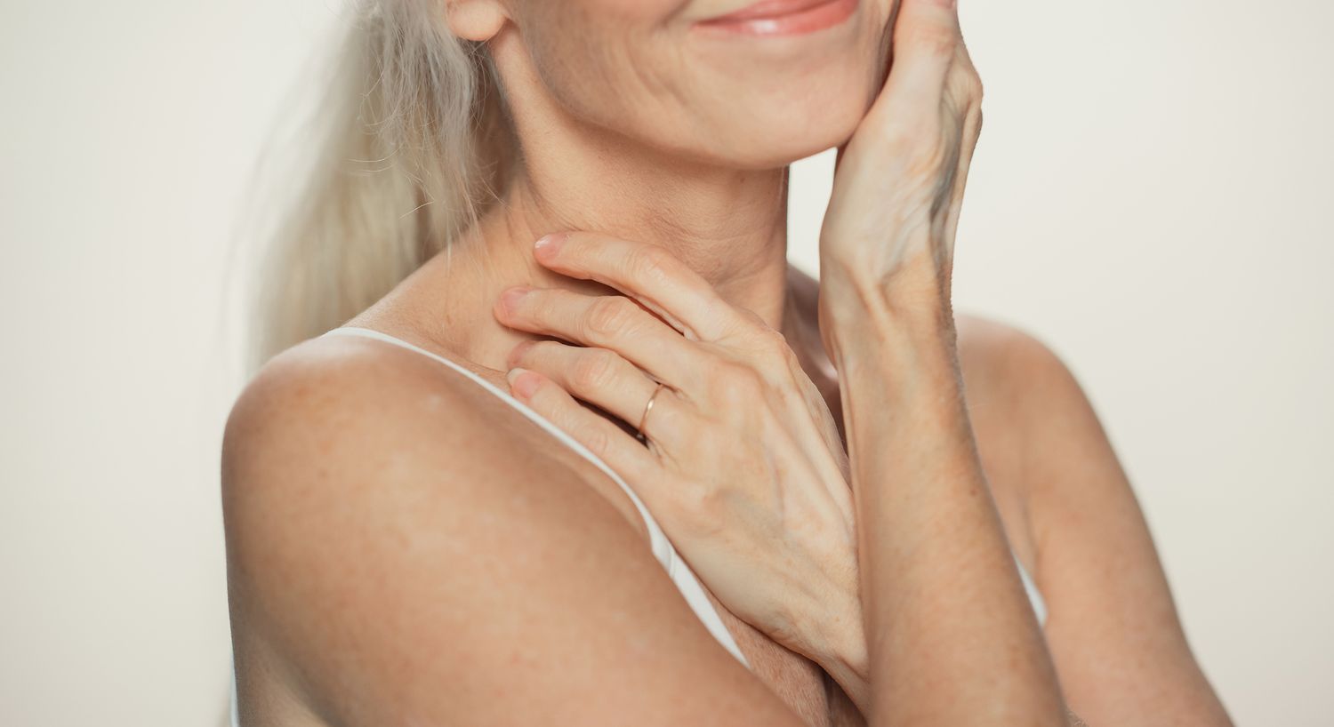 Woman gently touching her face and neck.